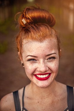 Portrait of a smiling red-haired woman with freckles: Annabelle Erickson.